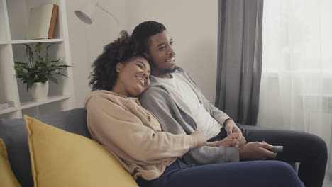 Young-Couple-Laughing-While-Watching-A-Film
