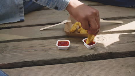 Friends-Sharing-Food-And-Dipping-Chicken-Nuggets-Into-Ketchup