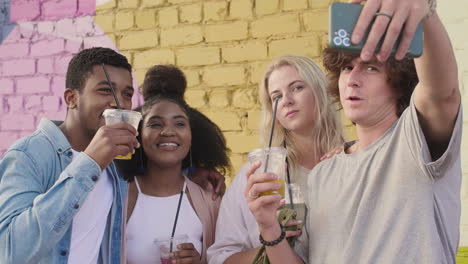Group-Of--Young-Friends-Taking-Selfies-Together-And-Having-Fun-Outdoors,-While-Holding-And-Drinking-Their-Fresh-Drinks-In-Plastic-Cups