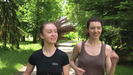 Two-Pretty-Sportswomen-Running-Outdoors-In-The-Park-1