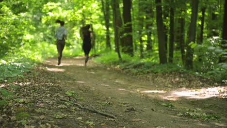 Back-View-Of-Two-Sportswomen-Running-In-The-Woods
