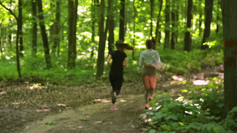 Back-View-Of-Two-Sportswomen-Running-In-The-Woods-1