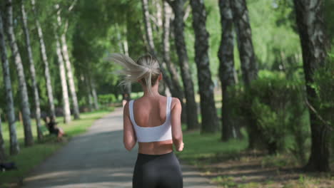 Back-View-Of-A-Pretty-Blonde-Girl-Running-In-The-Park