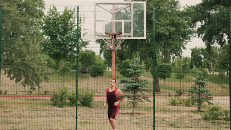 Männlicher-Basketballspieler,-Der-Während-Seiner-Trainingseinheit-Auf-Einem-Basketballplatz-Im-Freien-Dribbelt-Und-Ball-In-Den-Korb-Wirft