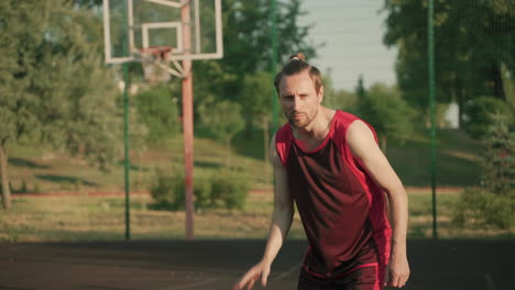 A-Focused-Handsome-Basketball-Player-Dribbling-In-An-Outdoor-Basketball-Court-In-A-Sunny-Day