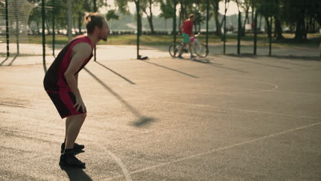 Skillfull-Male-Basketball-Player-Dribbling-Ball-Against-Opposing-Defender-And-Throwing-Ball-Into-Hoop-1
