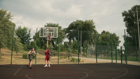 Two-Sportsmen-Playing-Basketball-In-An-Outdoor-Court