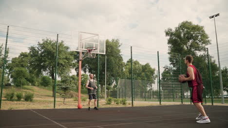 Zwei-Männliche-Basketballspieler-Trainieren-Gemeinsam-Auf-Einem-Basketballplatz-Im-Freien-1