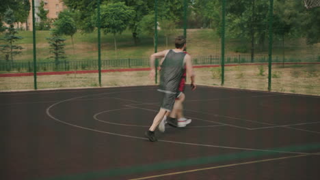 Two-Active-Sportsmen-Playing-In-An-Outdoor-Basketball-Court