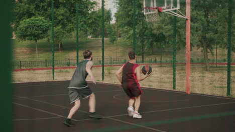 Zwei-Aktive-Sportler,-Die-Auf-Einem-Basketballplatz-Im-Freien-Spielen-1