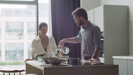 Happy-Couple-Drinking-Water-In-A-Modern-Kitchen