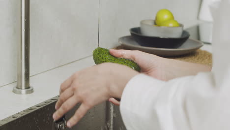 Nahaufnahme-Von-Frauenhänden,-Die-Zwei-Gurken-In-Einer-Modernen-Küchenspüle-Waschen