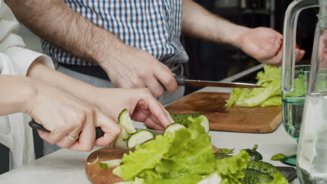 Close-Up-Of-Couple-Hands-Preparing-Food-Together-In-A-Modern-Kitchen