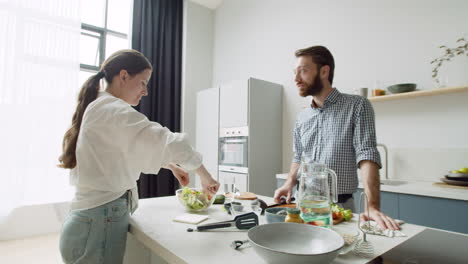 Young-Couple-Talking-And-Preparing-Food-Together-In-A-Modern-Kitchen