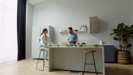 Cheerful-Couple-Chatting-And-Preparing-A-Tasty-Salad-In-A-Modern-Kitchen-2
