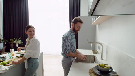 Lachendes-Paar,-Das-Gemeinsam-Das-Mittagessen-In-Einer-Modernen-Küche-Zubereitet