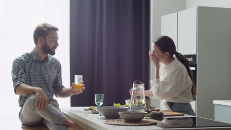 Cheerful-Couple-Chatting-And-Having-Lunch-Together-In-A-Modern-Style-Kitchen