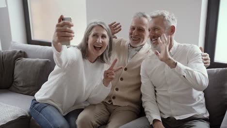 Gruppe-Glücklicher-älterer-Freunde,-Die-Auf-Der-Couch-Sitzen-Und-Ein-Selfie-video-Machen