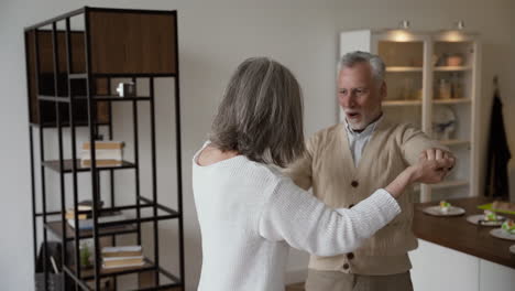 Happy-Senior-Couple-Dancing-And-Hugging-At-Home
