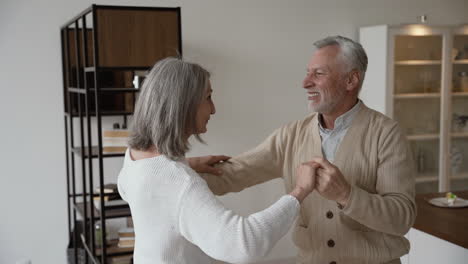 Happy-Senior-Couple-Dancing-And-Hugging-At-Home-1
