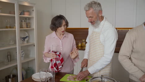 Older-Man-And-Woman-Friends-Cooking-And-Talking-In-The-Kitchen