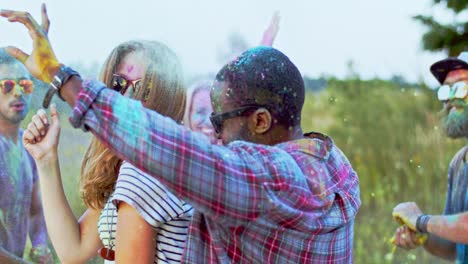 Mixed-Races-Joyful-Young-People-In-Colorful-Paints-Dancing-Together-And-Celebrating-Holi-Festival-Outside
