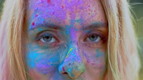 Close-Up-Of-The-Face-Of-The-Young-Blond-Beautiful-Woman-With-Colorful-Paints-On-Her-Face-Looking-Straight-To-The-Camera-And-Smiling