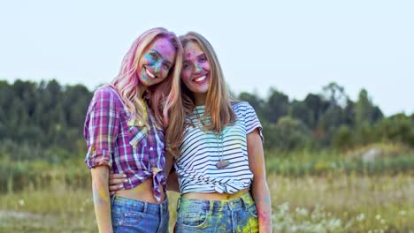 Portrait-Shot-Of-The-Two-Happy-And-Beautiful-Blonde-Young-Girls-Looking-At-Each-Other,-Hugging-And-Smiling-To-The-Camera,-Best-Friends-Having-Fun-At-The-Holi-Holiday