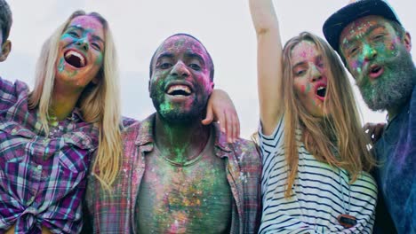 Close-Up-Of-The-Young-Mixed-Races-Cheerful-Friends-In-Colorful-Paints-During-Holi-Festival-Hugging-And-Laughing-To-The-Camera