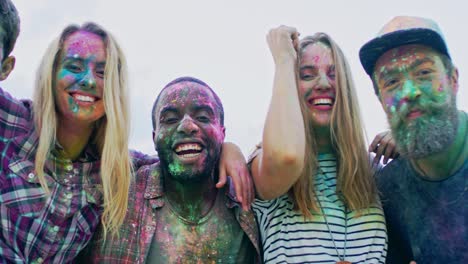 Multiethnic-Young-Happy-Girls-And-Guys-Having-Fun,-Hugging-And-Smiling-To-The-Camera-While-Celebrating-Holi-Holiday