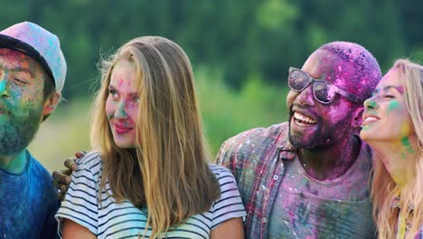 Friendly-Young-Multiethnic-Happy-Guys-And-Girls-In-Colorful-Paints-Smiling-And-Posing-To-The-Camera-Of-Smartphone-Outside-During-Holi-Fest