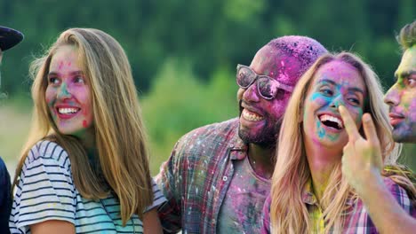 Close-Up-Of-The-Joyful-Young-Mixed-Races-Male-And-Female-Friends-Laughing-And-Celebrating-Holi-Holiday-Outdoors-While-Posing-To-The-Smartphone-Camera-And-Taking-Selfies-Photos