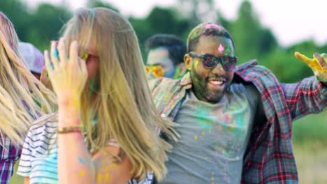 Cute-Young-Pretty-Girl-Laughing,-Having-Fun-And-Dancing-Among-Multiethnic-Friends-In-The-Field-At-The-Holi-Celebration