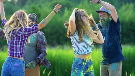 Two-Multiethnic-Young-Couples-Dancing-Happily-And-Celebrating-Holi-Festival-With-Paints-At-The-Green-Field