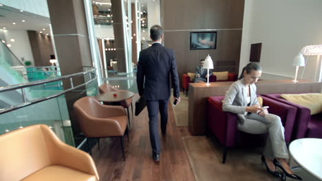 Businessman-Holding-A-Briefcase-And-Entering-A-Hotel-Hall-While-Talking-On-The-Phone