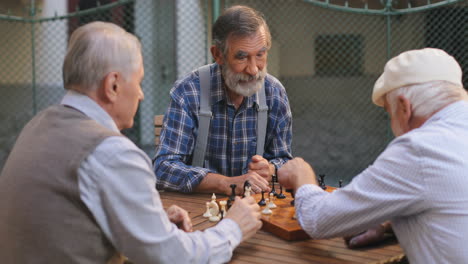 Old-Male-Friends-Playing-Chess-In-The-Yard