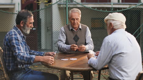 Senior-Man-On-Retirement-Playing-Cards-With-His-Two-Best-Old-Friends-Neighbors-In-The-Yard-On-The-Fresh-Air