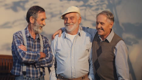 Three-Old-Men-Coming-In-The-Shot,-Standing-And-Posing-To-The-Camera-With-Smiles-At-The-Wall