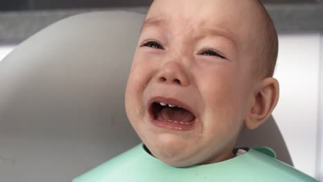 Close-Up-Of-Stroppy-Baby-Boy-Crying-During-Feeding