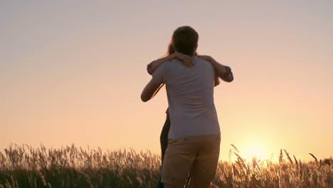 Couple-Hugging-And-Kissing-In-A-Wheat-Field-At-Sunset