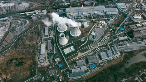 Aerial-View-Of-Industrial-Zone-With-Factories-Expelling-Smoke-Around-A-Green-Landscape-1