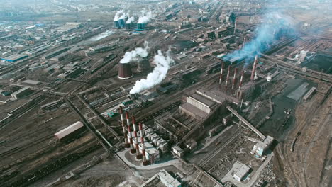 Aerial-View-Of-Industrial-Zone-With-Factories-Expelling-Smoke-Around-A-Green-Landscape-2