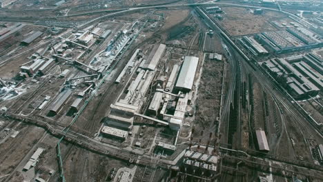 Aerial-View-Of-Industrial-Zone-With-Factories-Expelling-Smoke-Around-A-Green-Landscape-3