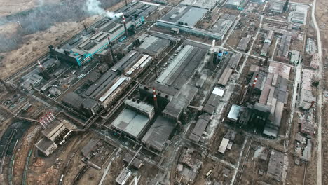 Aerial-View-Of-Industrial-Zone-With-Factories-Expelling-Smoke-Around-A-Green-Landscape-4