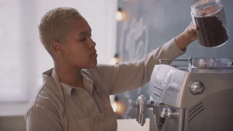 Afro-muslimische-Kellnerin-Gießt-Kaffee-In-Die-Kaffeemaschine
