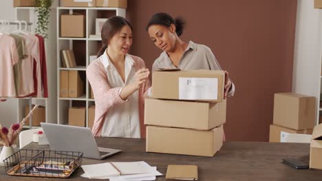 Frau-Und-Frau,-Die-In-Ihrem-Geschäft-Arbeiten,-Organisieren-Kartons-Zur-Lieferung