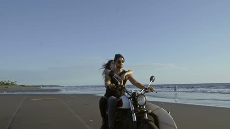 Couple-Riding-A-Motorcycle-On-The-Beach