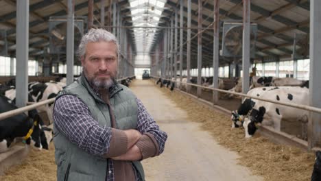 Camera-Focuses-On-A-Farmer-In-A-Farm-With-Cows-Around