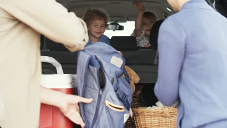 Die-Familie-Fährt-In-Den-Urlaub,-Die-Eltern-Verstauen-Das-Gepäck-Im-Kofferraum-Und-Die-Kleinen-Kinder-Warten-Im-Auto-Sitzend-1