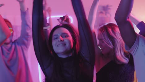 Group-Of-Friends-Dancing-At-A-Party-With-Neon-Lights-Decoration